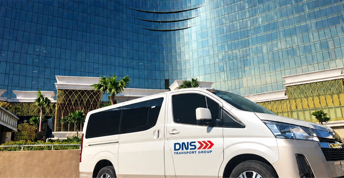 Illustrative DNS-branded hotel transport van outside a hotel